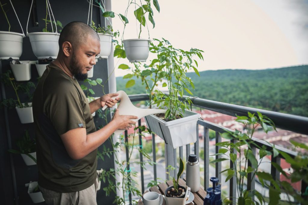 Man gardening on an apartment balcony