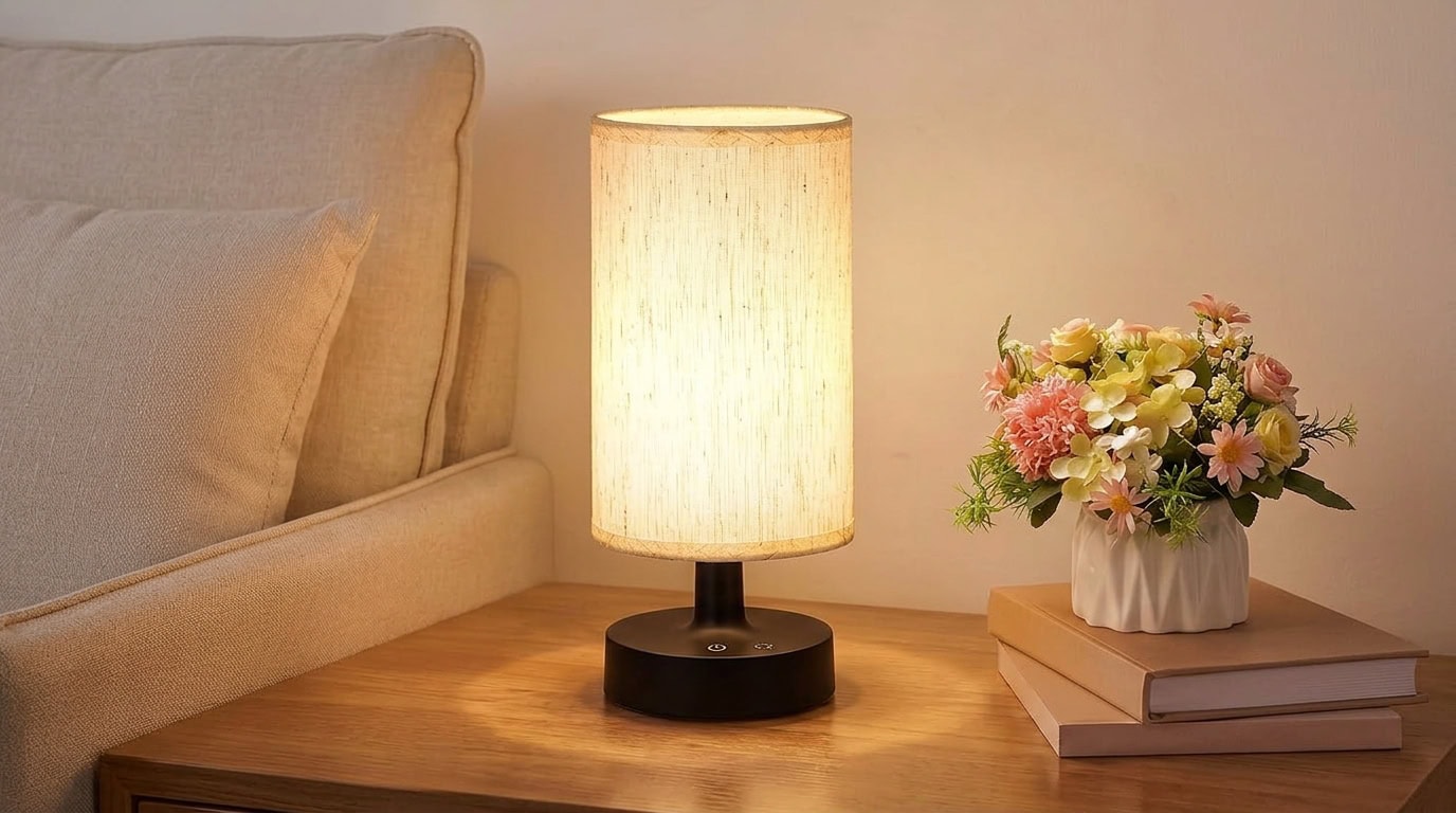Warm bedroom scene with bedside lamp, flowers, and books for a relaxing atmosphere.